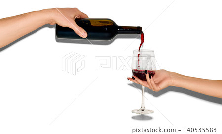Hand pouring red wine into glass isolated on white background with copy space Hand pouring red wine into glass isolated on white background with copy space 140535583