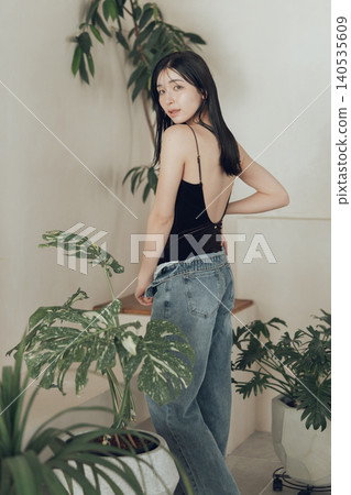 A woman wearing a swimsuit and denim outfit. A woman wearing a swimsuit and denim outfit. 140535609