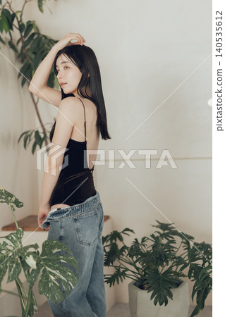 身穿泳衣和牛仔服的女士。 140535612