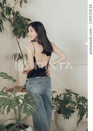 A woman wearing a swimsuit and denim outfit. A woman wearing a swimsuit and denim outfit. 140535616
