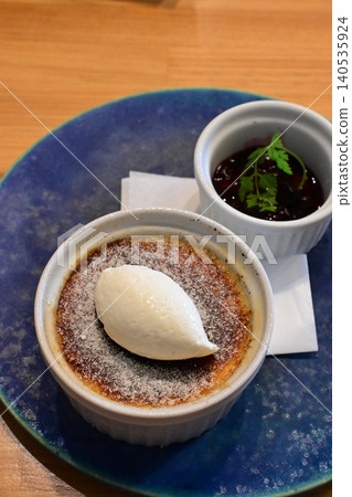 A dessert plate of crème brûlée and berry sauce to enjoy at a cafe. 140535924