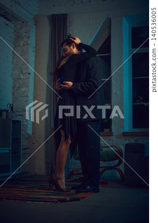 Couple hugging after engagement proposal holding ring box at home. 140536005