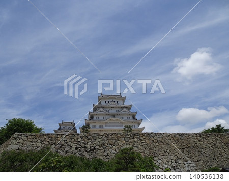The magnificent view of Himeji Castle's main keep and west keep standing side by side beyond the towering, long stone walls. 140536138