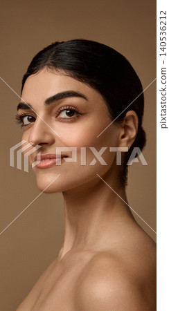Confident beauty model with glowing skin on warm beige studio background. Confident beauty model with glowing skin on warm beige studio background. 140536212