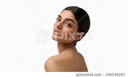 Elegant woman looking over shoulder with smooth radiant skin on white background. 140536265