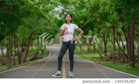 Black woman with towel on park path for outdoor fitness 140536267