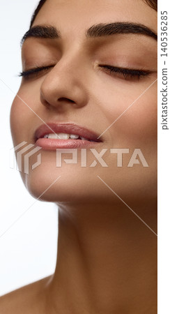 Close up of woman face with closed eyes and glossy lips on white background. Close up of woman face with closed eyes and glossy lips on white background. 140536285