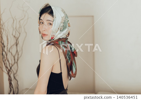 A young woman with a scarf wrapped around her head A young woman with a scarf wrapped around her head 140536451