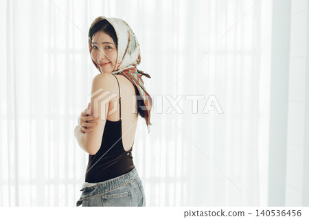 A young woman with a scarf wrapped around her head 140536456