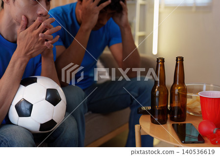 Multiracial men reacting with disappointment watching soccer game at home Multiracial men reacting with disappointment watching soccer game at home 140536619