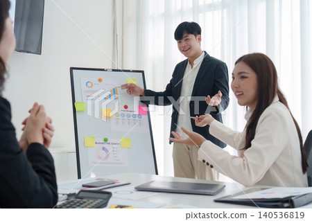 Asian businessman giving presentation with charts to colleagues in office 140536819