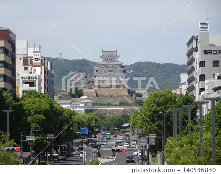 A view from Otemae Street of the towering main keep of Himeji Castle, a World Heritage Site, and the surrounding townscape against the blue sky. 140536830