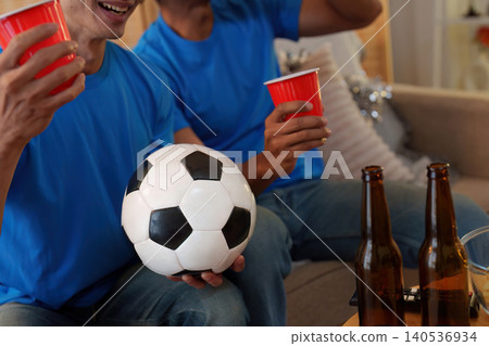 Asian men watching soccer game in living room for sports fans Asian men watching soccer game in living room for sports fans 140536934