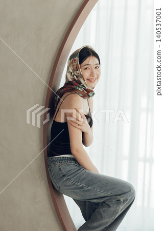 A woman wearing a swimsuit and denim scarf on her head. A woman wearing a swimsuit and denim scarf on her head. 140537001