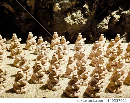 Countless small Benzaiten statues, dedicated to the goddess of fortune, are neatly arranged on the rock face of the cave. Countless small Benzaiten statues, dedicated to the goddess of fortune, are neatly arranged on the rock face of the cave. 140537021