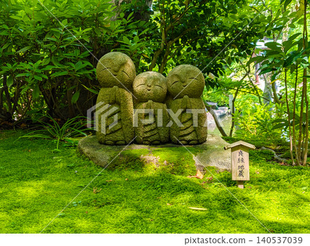 The Jizo statue for finding love stands amidst the beautiful moss garden of Hase-dera Temple in Kamakura, surrounded by the vibrant new greenery of early summer. The Jizo statue for finding love stands amidst the beautiful moss garden of Hase-dera Temple in Kamakura, surrounded by the vibrant new greenery of early summer. 140537039