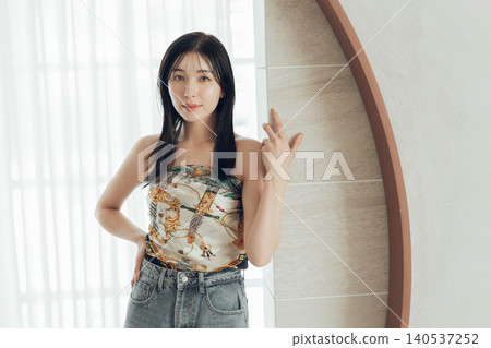 一位女士將圍巾圍在身上,這是她時尚裝扮的一部分。 一位女士將圍巾圍在身上,這是她時尚裝扮的一部分。 140537252