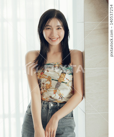 一位女士將圍巾圍在身上，這是她時尚裝扮的一部分。 140537254