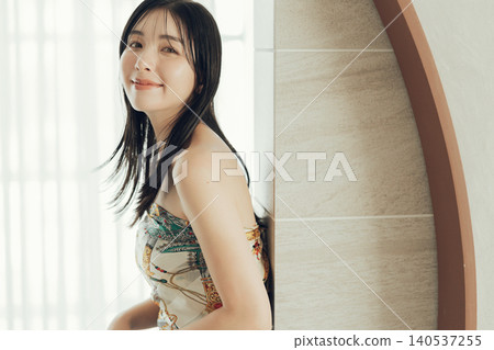 A woman wearing a scarf around her body as part of her fashion. A woman wearing a scarf around her body as part of her fashion. 140537255