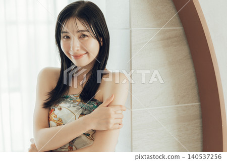 A woman wearing a scarf around her body as part of her fashion. A woman wearing a scarf around her body as part of her fashion. 140537256