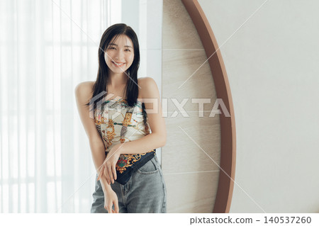 一位女士將圍巾圍在身上,這是她時尚裝扮的一部分。 一位女士將圍巾圍在身上,這是她時尚裝扮的一部分。 140537260