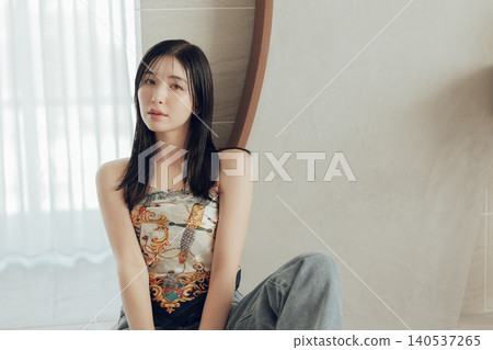 A woman wearing a scarf around her body as part of her fashion. A woman wearing a scarf around her body as part of her fashion. 140537265