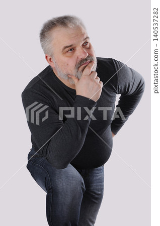 Thoughtful mature bearded man thinking and making decision isolated on gray background Thoughtful mature bearded man thinking and making decision isolated on gray background 140537282