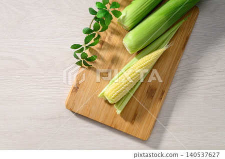 Fresh baby corn and a wooden cutting board Fresh baby corn and a wooden cutting board 140537627