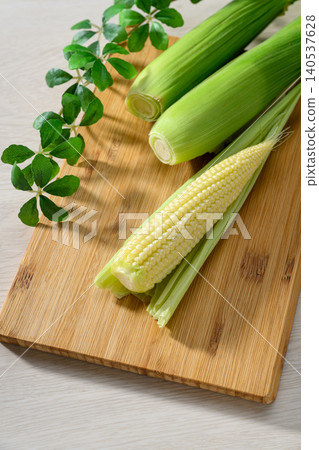 Fresh baby corn and a wooden cutting board Fresh baby corn and a wooden cutting board 140537628