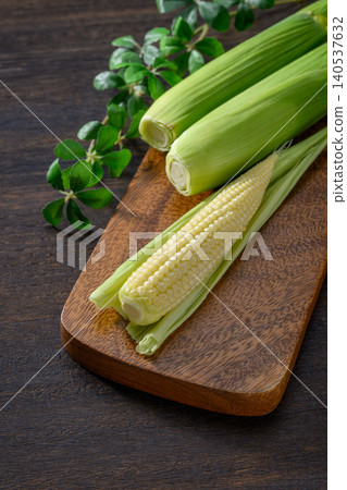 Fresh baby corn and a wooden cutting board Fresh baby corn and a wooden cutting board 140537632