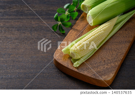 Fresh baby corn and a wooden cutting board Fresh baby corn and a wooden cutting board 140537635