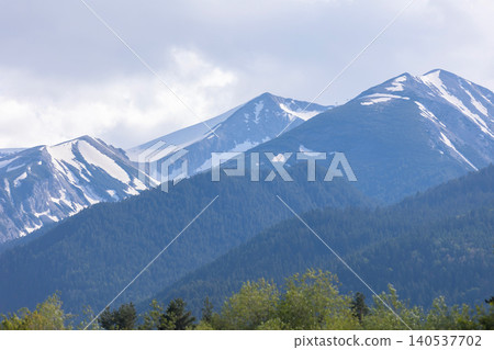 Snow-capped Pirin Mountains with dense evergreen forests and cloudy sky in Bansko, Bulgaria Snow-capped Pirin Mountains with dense evergreen forests and cloudy sky in Bansko, Bulgaria 140537702