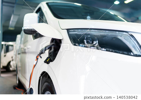 Close up of electric delivery van with connected charging cable Close up of electric delivery van with connected charging cable 140538042