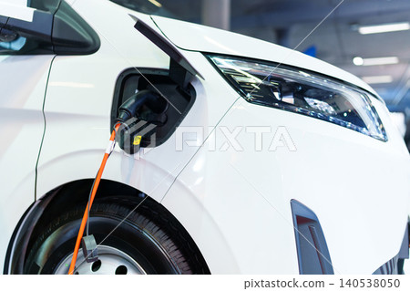 Close up of electric delivery van with connected charging cable Close up of electric delivery van with connected charging cable 140538050
