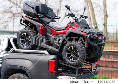 Truck with red quad bike in the trunk 140538078