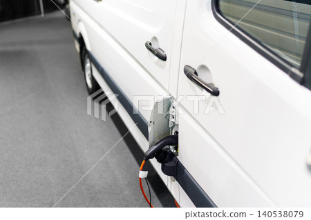 Close up of electric delivery van with connected charging cable Close up of electric delivery van with connected charging cable 140538079