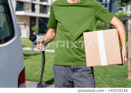Driver with charging plug next to of electric van. Driver with charging plug next to of electric van. 140538146