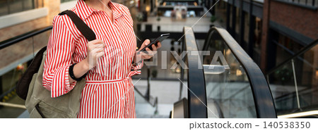 Woman with a mobile phone in a shopping mall. Woman with a mobile phone in a shopping mall. 140538350