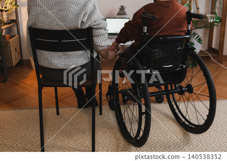 A woman with her boyfriend with disability holding hands A woman with her boyfriend with disability holding hands 140538352