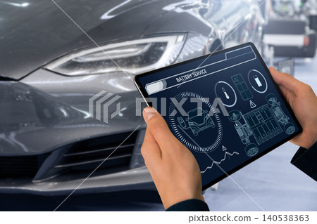 Technician checks the battery pack of an electric car at a service center. 140538363