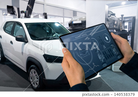 Technician checks the battery pack of an electric car at a service center. 140538379