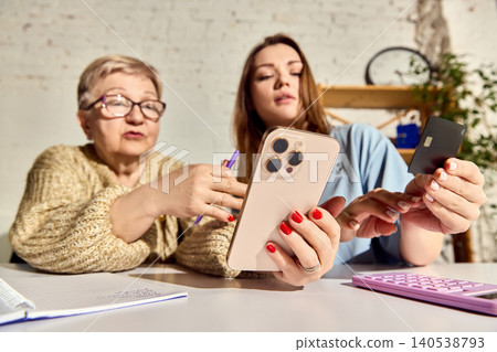 Close view of women using smartphone and bank card for online transfer. 140538793