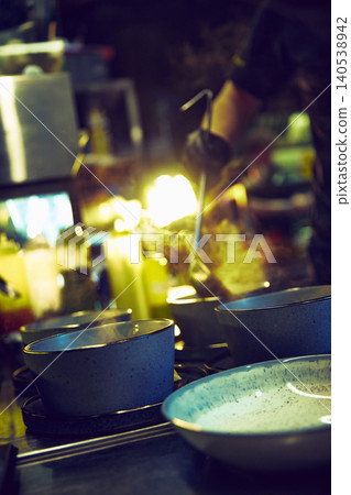 Steaming bowls waiting on restaurant pass under warm kitchen lights Steaming bowls waiting on restaurant pass under warm kitchen lights 140538942
