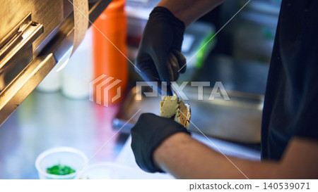 Chef spreading savory cream on toasted bread in restaurant kitchen Chef spreading savory cream on toasted bread in restaurant kitchen 140539071
