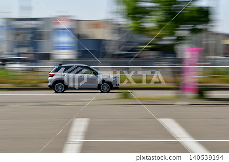 Panning shot of an SUV driving on a suburban road. Panning shot of an SUV driving on a suburban road. 140539194