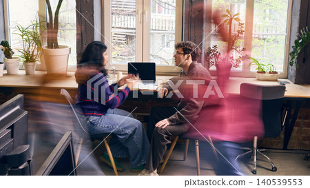 Focused office workers having one on one business conversation in coworking space. Focused office workers having one on one business conversation in coworking space. 140539553