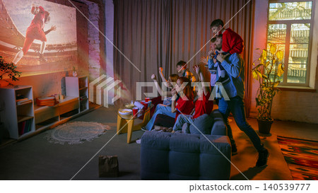 Big family watching soccer projection at home with kids cheering on couch. Big family watching soccer projection at home with kids cheering on couch. 140539777