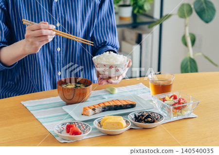 A young woman's hands as she eats breakfast at home A young woman's hands as she eats breakfast at home 140540035