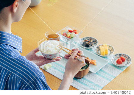 A young woman's hands as she eats breakfast at home A young woman's hands as she eats breakfast at home 140540042