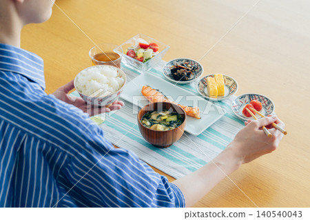 A young woman's hands as she eats breakfast at home A young woman's hands as she eats breakfast at home 140540043